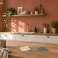 Mur terracotta dans une cuisine blanche et bois avec échantillons de peinture