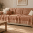 Grand jeté en coton terracotta et crème couvrant l’assise et le dossier d’un canapé beige